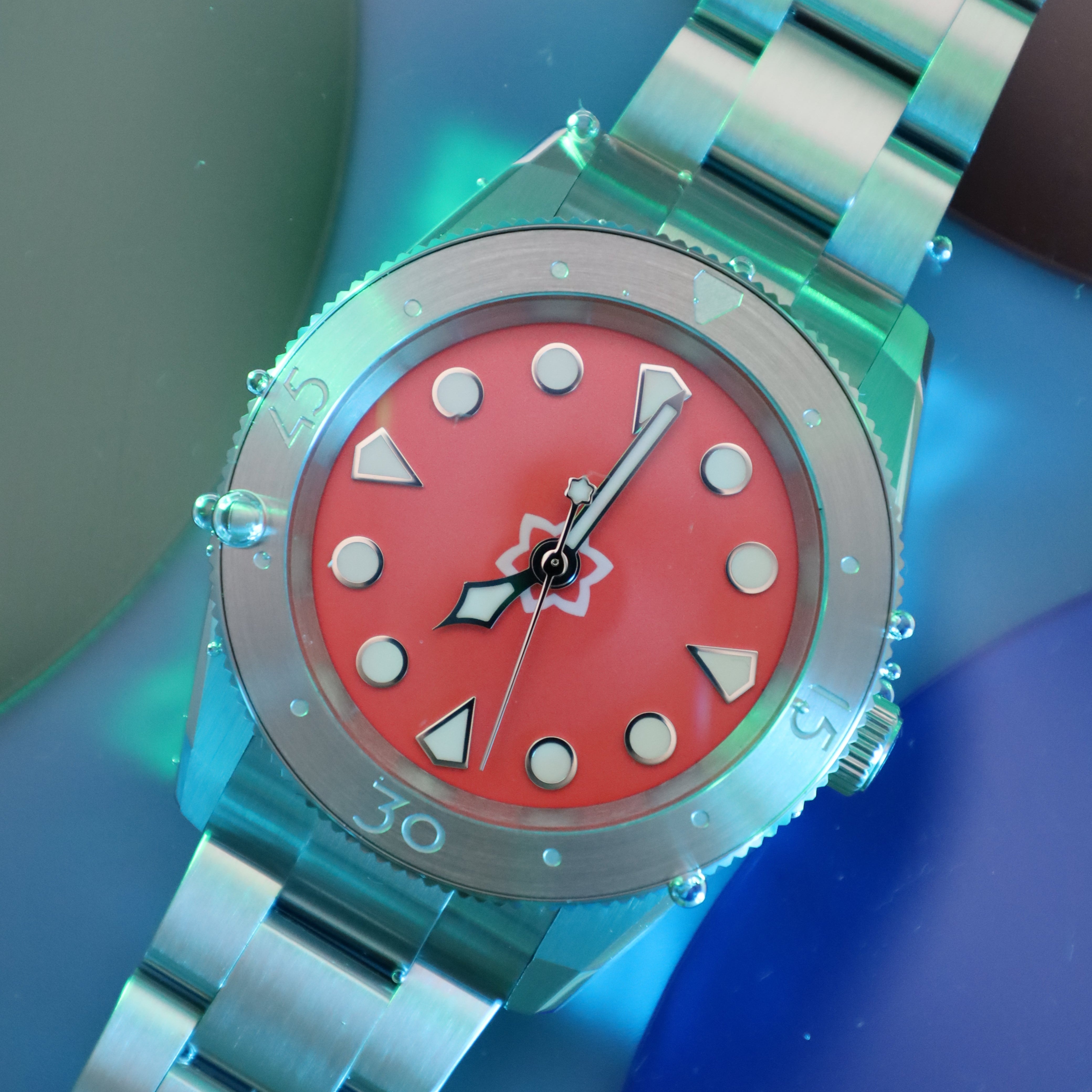 Watch with a red face and silver band on a blue background